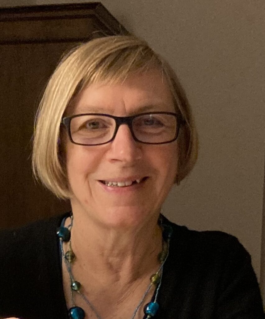 Petra Wagner lächelt in die Kamera. Sie trägt die blonden Haare offen und ein dunkles Oberteil passend zu ihrer Brille